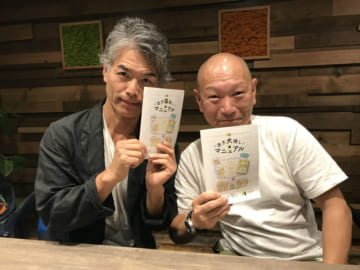「迷子捜しマニュアル」を持つ（左から）藤原博史さん、田中政行さん