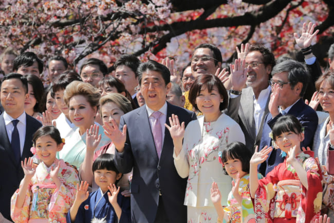 「桜を見る会」で招待客と記念撮影する安倍晋三首相（中央）（2019年4月、時事）