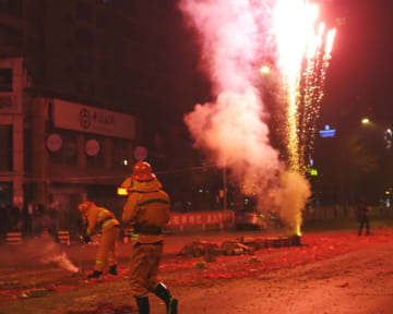 春節を花火や爆竹で祝う北京の街。消防士が火を消す姿も（2017年1月、EPA＝時事）