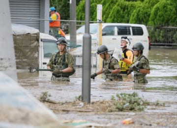 「常総水害」で、冠水した住宅地を捜索する自衛隊員（2015年9月、時事）