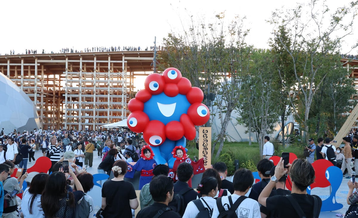  大阪・関西万博が閉幕の日を迎え、巨大な「ミャクミャク像」の周辺で記念撮影する人々（2025年10月13日、時事通信フォト）